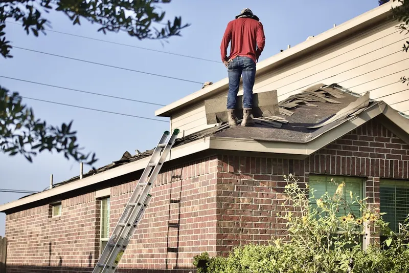 Professional roofer working on a residential roof in New Madison